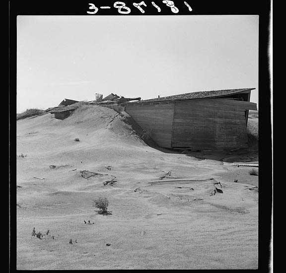 Wall of dust pushes up against a dilapidated farm house