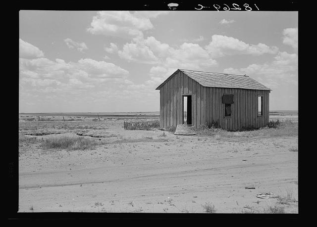 Abandoned small house against dirt road