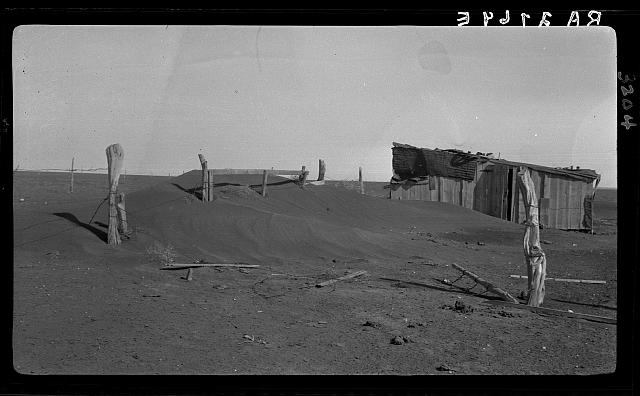 Fence corner and outbuilding being buried by dust